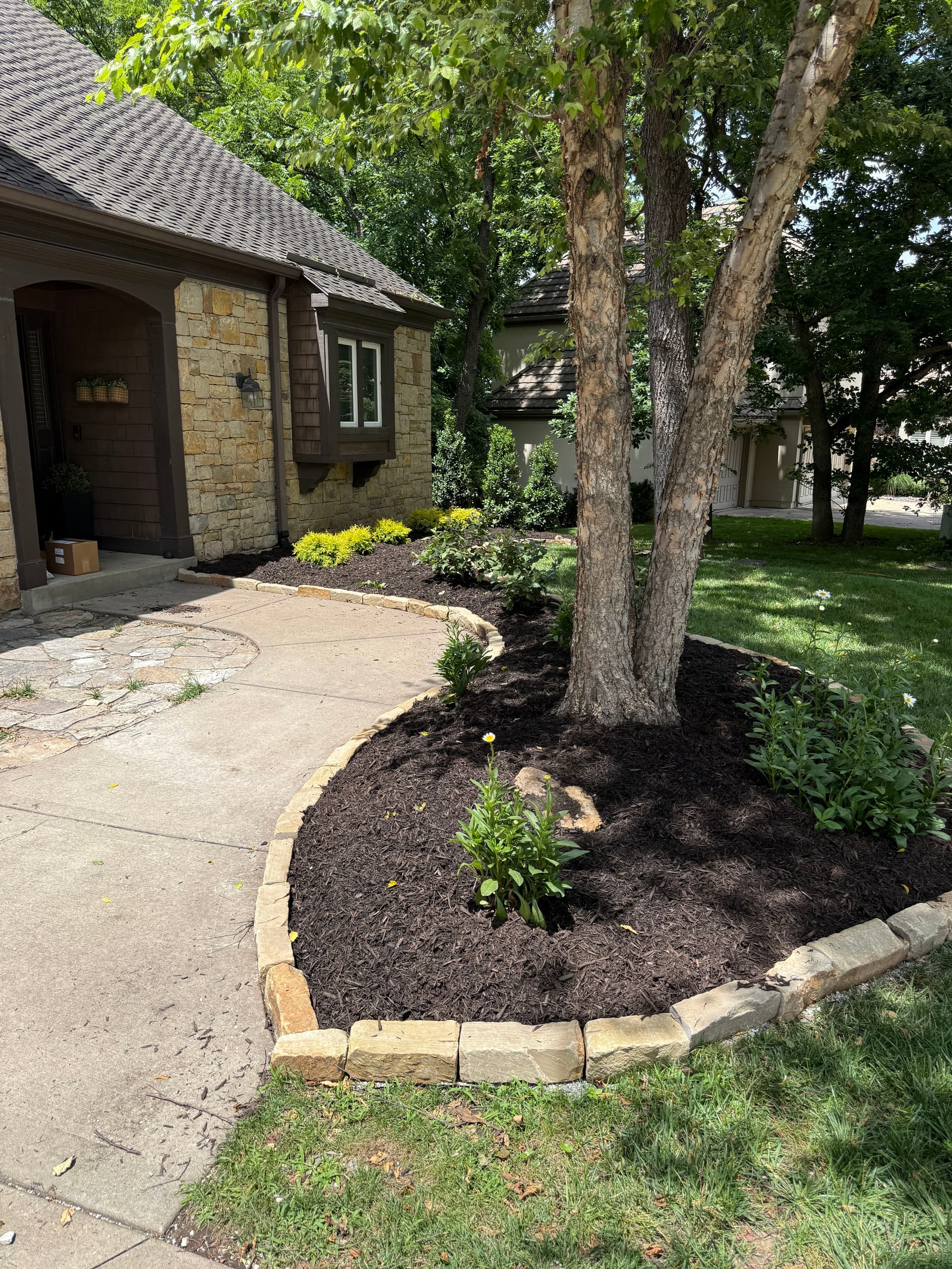 Stone Edging, Shrubs, and Mulch Give This Lenexa Home a Clean Reset image